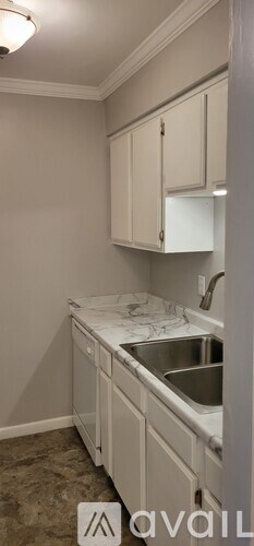 A kitchen with white cabinets and a marble countertop.
