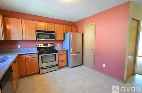A kitchen with wooden cabinets and a refrigerator.