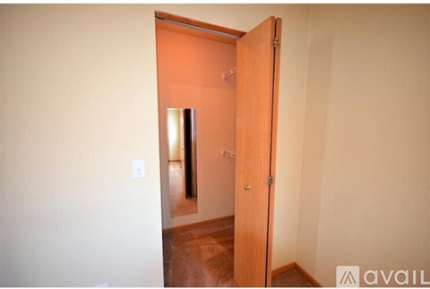 A wooden door is open to a room with a light switch on the wall.