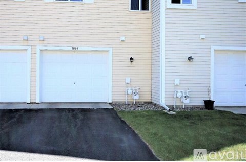 A house with two white garage doors and a driveway.