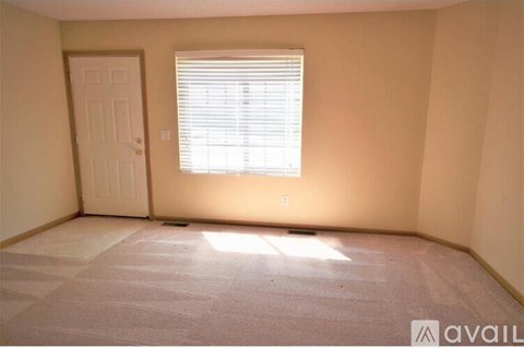 A room with a door and a window with blinds.