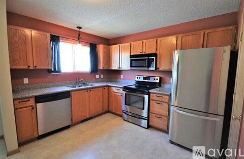 A kitchen with wooden cabinets and stainless steel appliances.