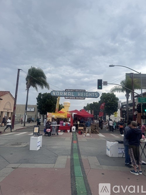 A street view of Normal Heights with a crowd of people and a tent.