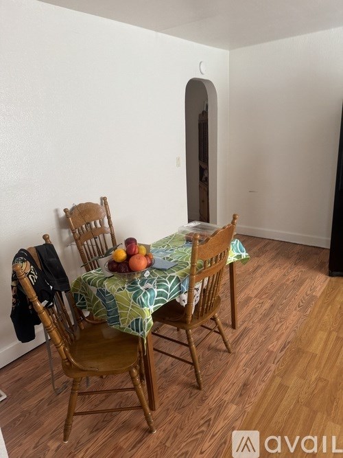 A table with a green tablecloth and a bowl of fruit on it.