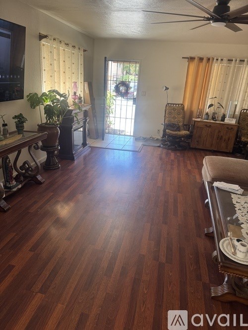 A room with wooden floors and a ceiling fan.
