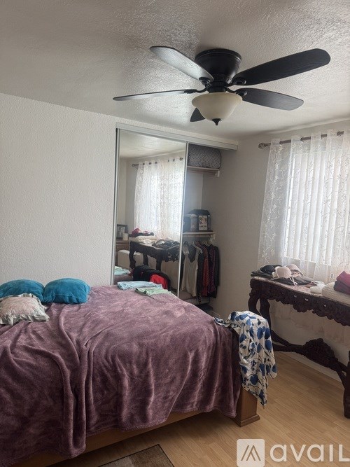 A bedroom with a bed, a dressing table, and a mirror.
