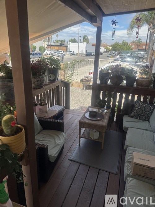 A patio with a couch, table, and potted plants.