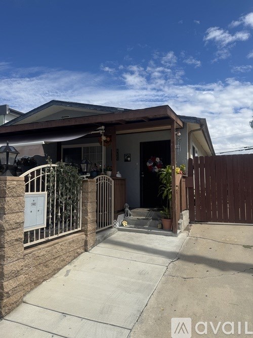 A house with a brown fence and a white gate.