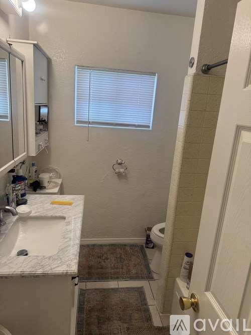 A bathroom with a sink, mirror, and toilet.