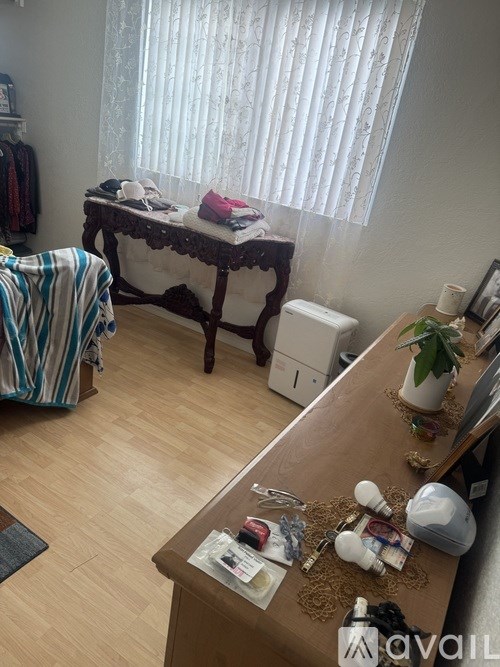 A room with a wooden table and a window with blinds.