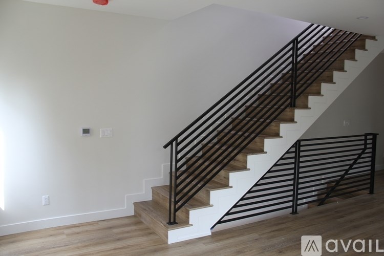 A staircase with wooden steps and black metal railings.