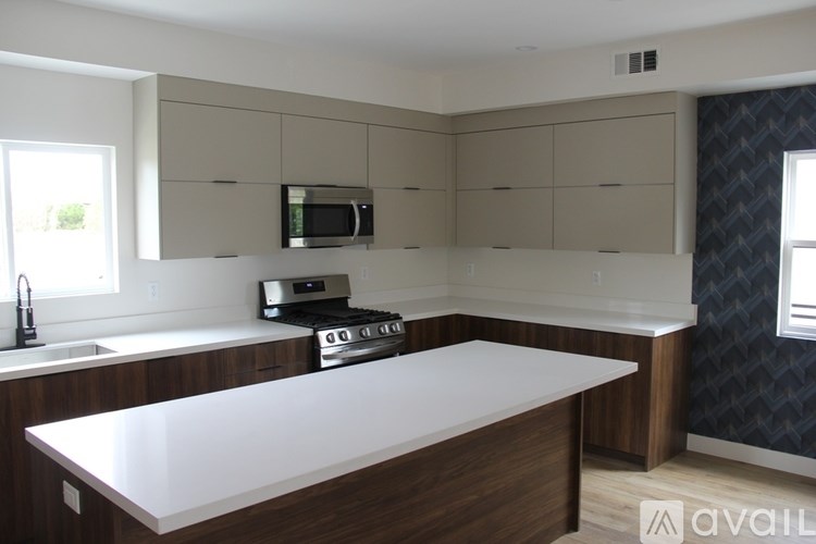 A kitchen with a white countertop and a microwave above it.