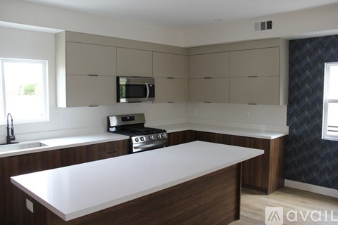 A kitchen with a white countertop and a microwave above it.