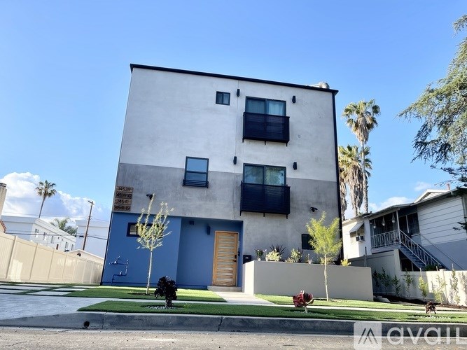 A modern two-story house with a blue door and windows.