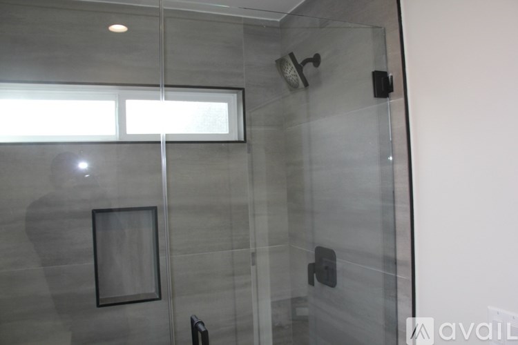 A bathroom with a glass shower door and a picture on the wall.