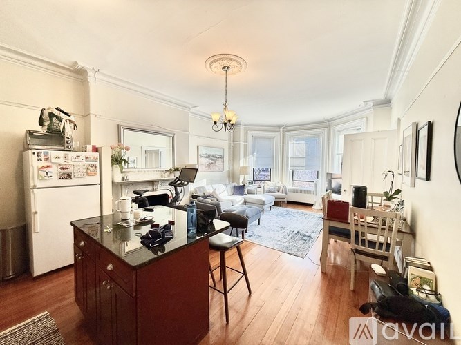 A kitchen with a black countertop and a white refrigerator.