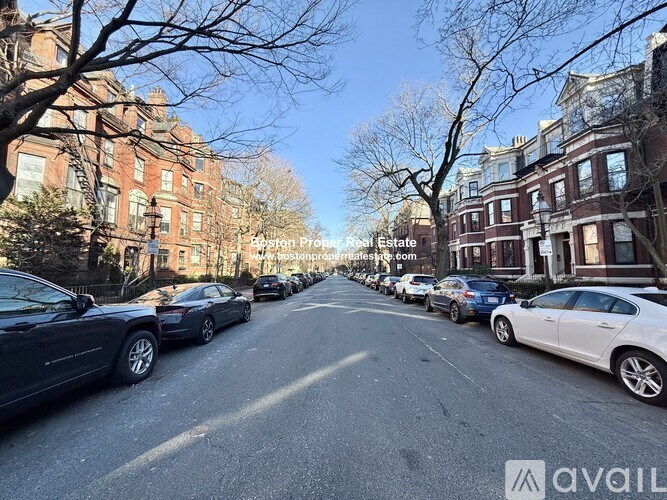 A street view of a residential area with cars parked on the side.