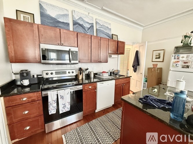 A kitchen with brown cabinets and a stove top oven.