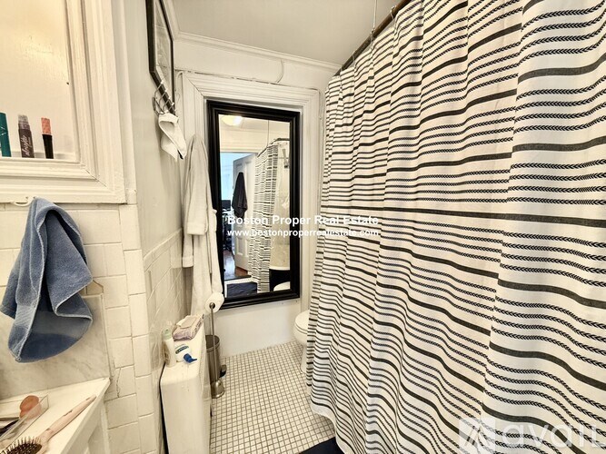 A bathroom with a shower curtain that has a wavy pattern.