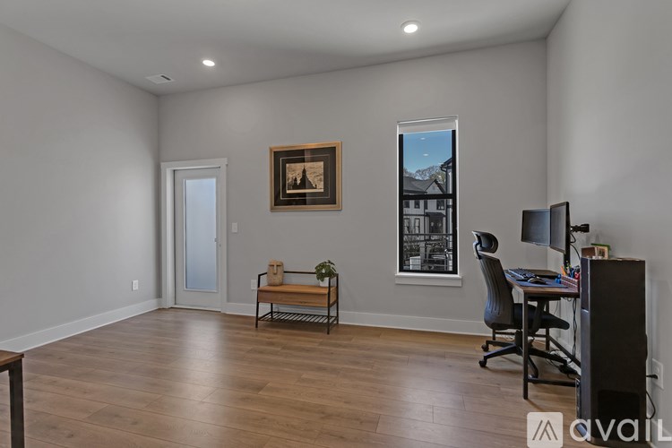 A room with a desk, chair, and a painting on the wall.