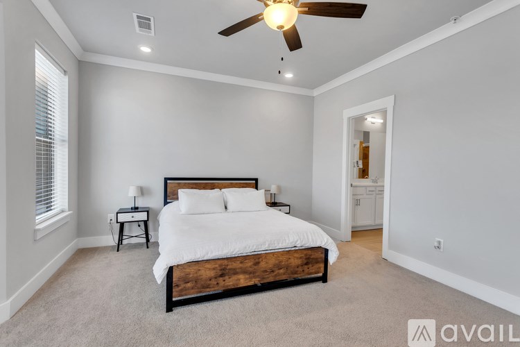 A bedroom with a large bed and a ceiling fan.