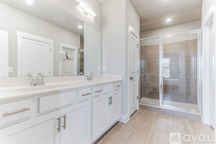A bathroom with two sinks and a walk-in shower.