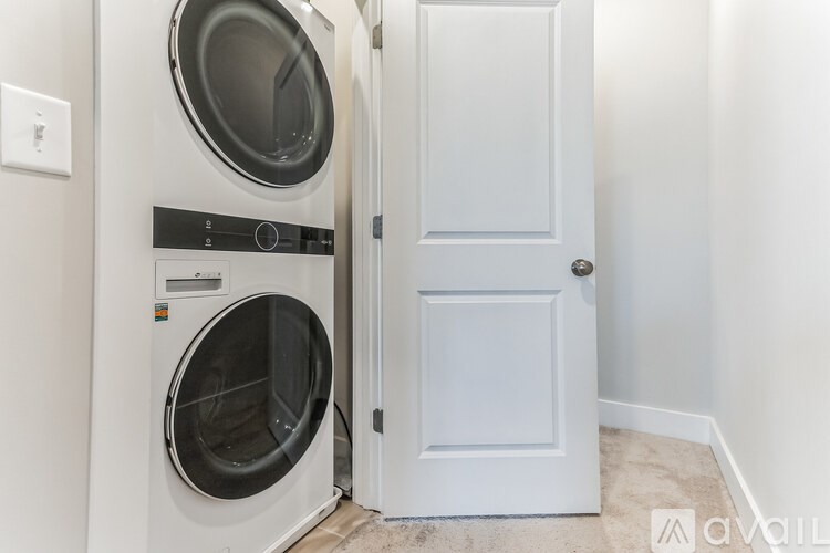 A white door is open to a laundry room with a washing machine.
