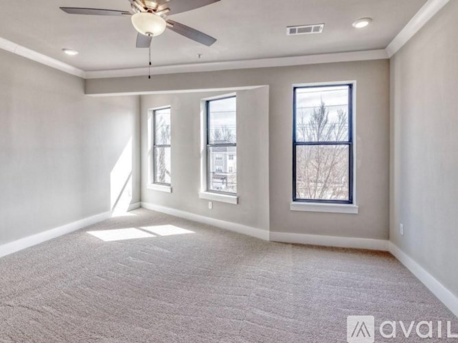 A spacious room with a ceiling fan and carpeted floor.