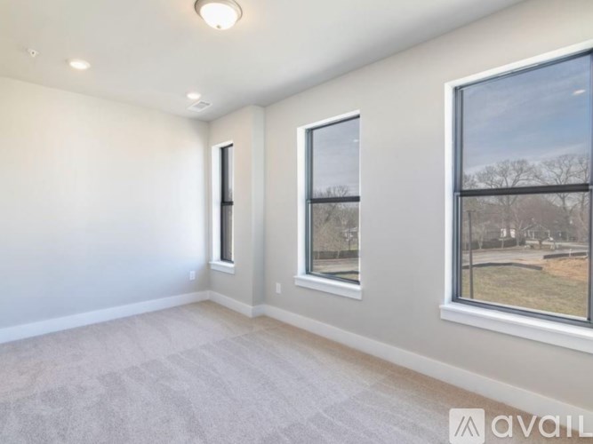 A room with a carpeted floor and two windows.
