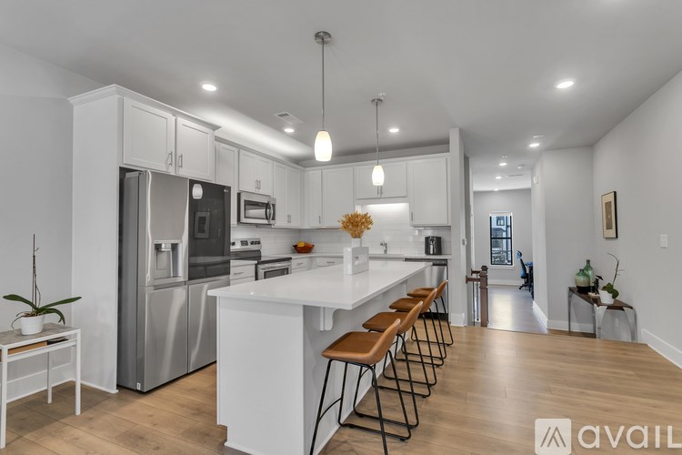 A modern kitchen with stainless steel appliances and wooden flooring.