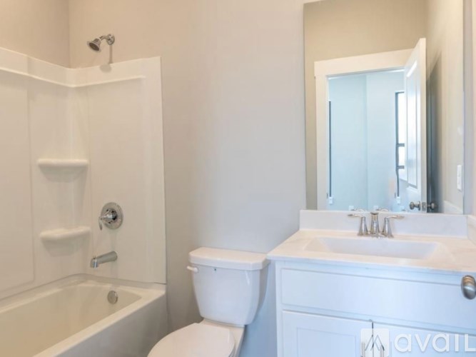 A white bathroom with a toilet, sink, and bathtub.