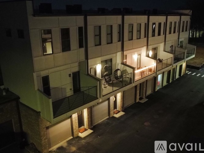 A building with balconies and lights on at night.