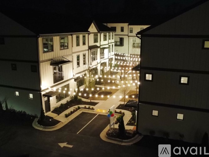 A building with a lit up entrance and a statue in front.