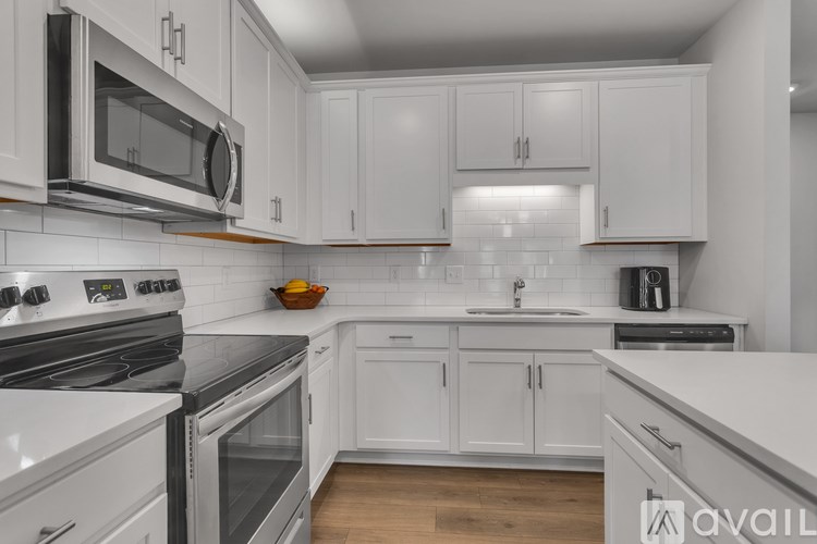 A modern kitchen with white cabinets and appliances.