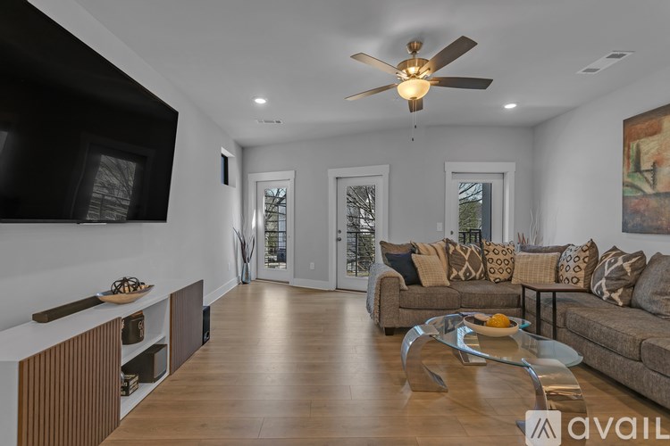 A modern living room with a brown couch and a wooden floor.