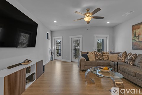 A modern living room with a brown couch and a wooden floor.