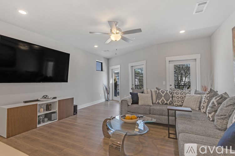A modern living room with a grey couch and a wooden coffee table.