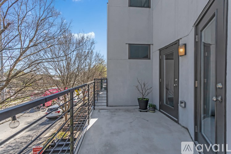 A balcony with a metal railing and a potted plant.