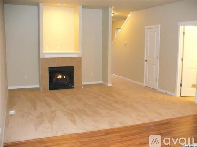 A living room with a fireplace and a wooden floor.