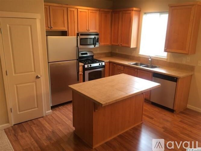 A kitchen with wooden cabinets and a white door.