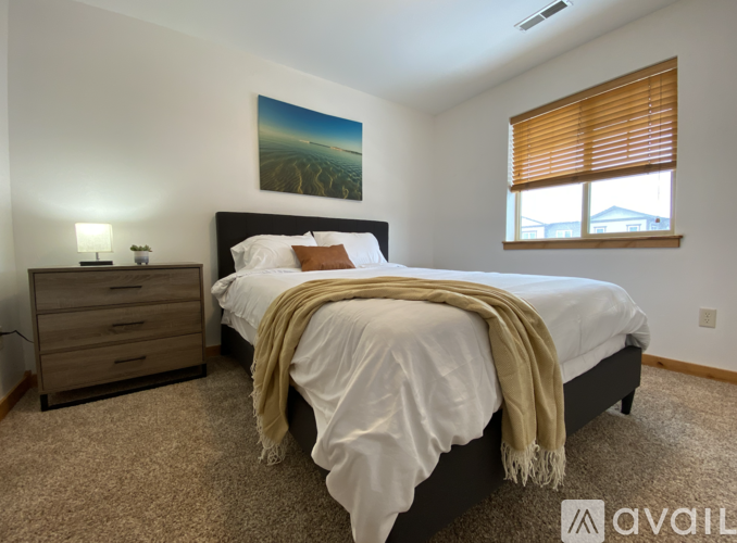 A bedroom with a large bed and a painting on the wall.