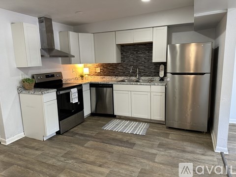 A kitchen with a stainless steel refrigerator, oven, and cabinets.