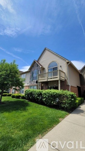 A house with a well-maintained lawn and a clear sky.