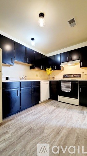 A kitchen with black cabinets and a white oven.