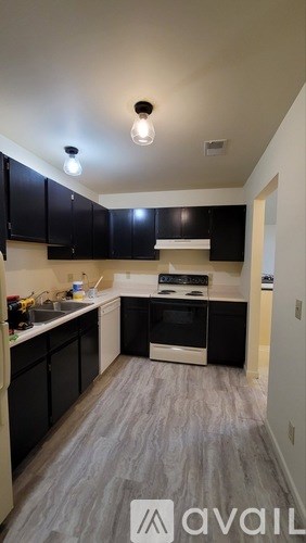 A kitchen with black cabinets and a white oven.