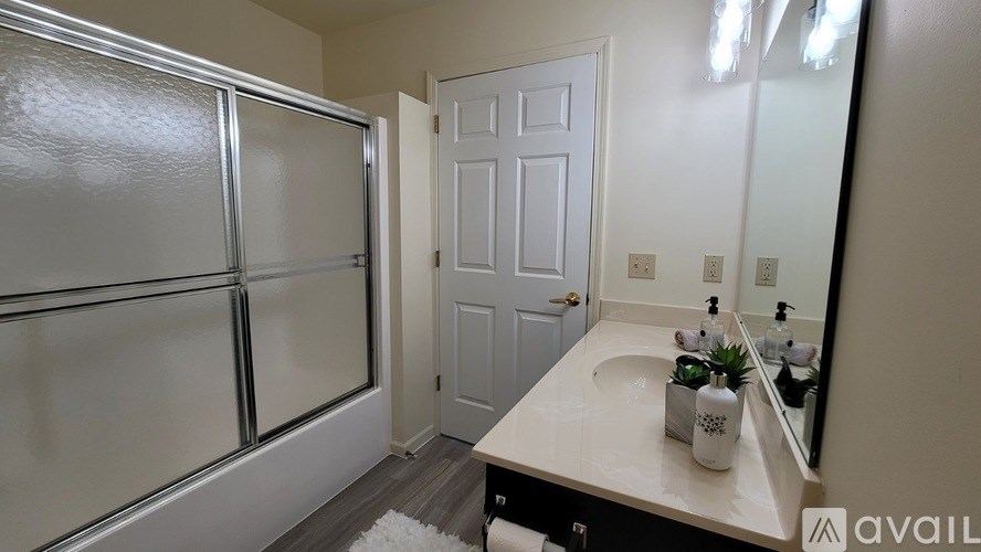 A bathroom with a white sink and a white door.