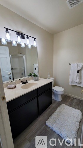 A bathroom with a white rug on the floor.