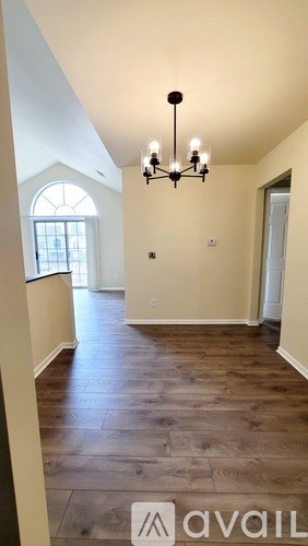 A room with wooden floors and a chandelier.