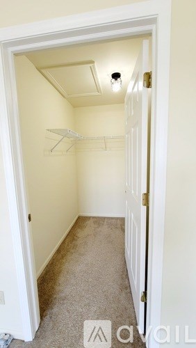 A small, empty room with a carpeted floor and a white door.