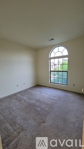 A room with a carpeted floor and a large window.